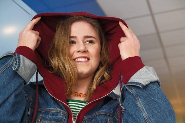 Meisje met hoodie trekt capuchon over hoofd